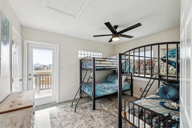 bedroom featuring multiple windows, hardwood / wood-style flooring, access to exterior, and ceiling fan