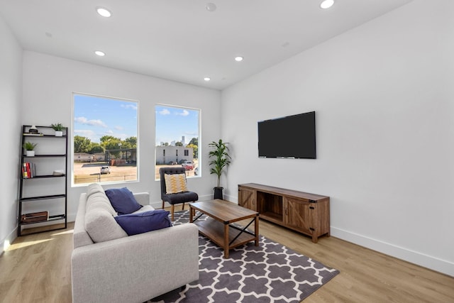 living room with light wood finished floors, recessed lighting, and baseboards