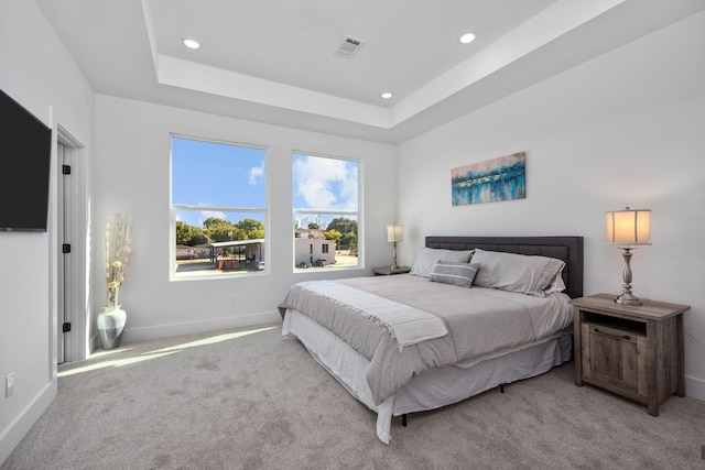 carpeted bedroom featuring recessed lighting, visible vents, baseboards, and a raised ceiling