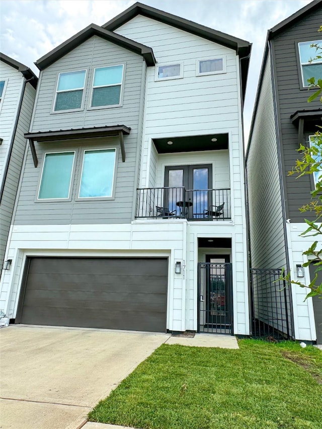 view of front facade featuring a balcony, a garage, and driveway