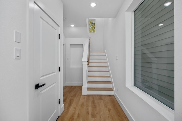 stairway with recessed lighting, wood finished floors, and baseboards