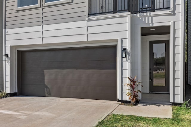 doorway to property featuring concrete driveway and an attached garage