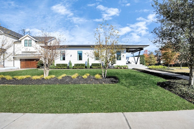 view of front of house with a garage, covered porch, and a front yard