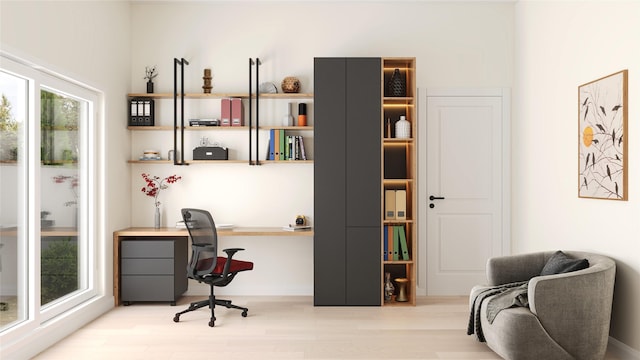 home office with light hardwood / wood-style flooring