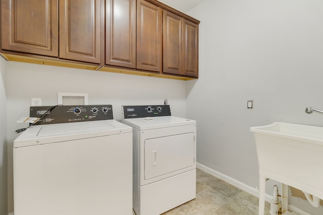 laundry room featuring separate washer and dryer, sink, and cabinets