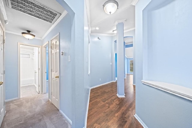 corridor with crown molding, dark hardwood / wood-style flooring, and ornate columns