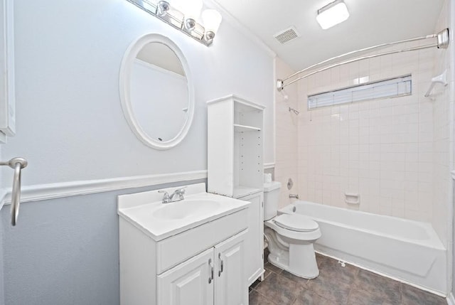 full bathroom with vanity, tiled shower / bath combo, and toilet