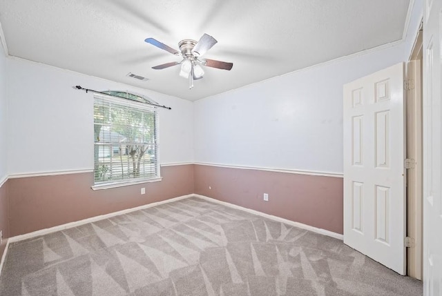 carpeted spare room with ceiling fan and a textured ceiling