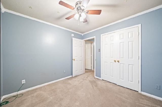 unfurnished bedroom featuring light carpet, crown molding, a closet, and ceiling fan