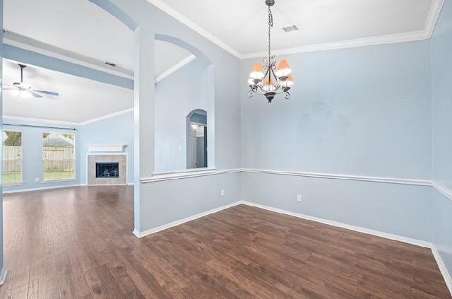 empty room with a tiled fireplace, hardwood / wood-style floors, crown molding, and ceiling fan with notable chandelier