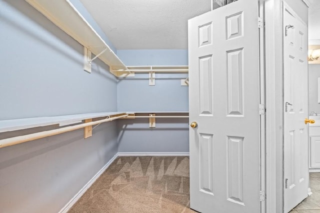 walk in closet featuring light colored carpet