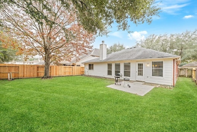 rear view of house with a patio and a yard