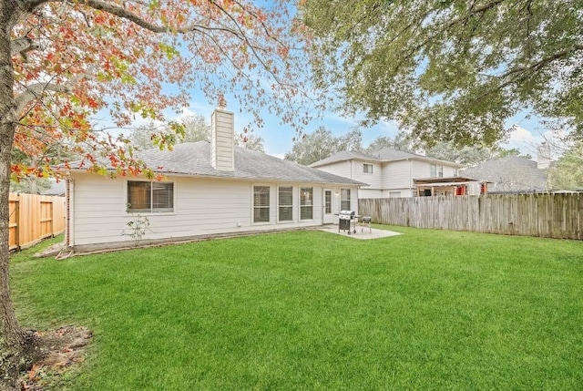 rear view of property featuring a patio area and a lawn