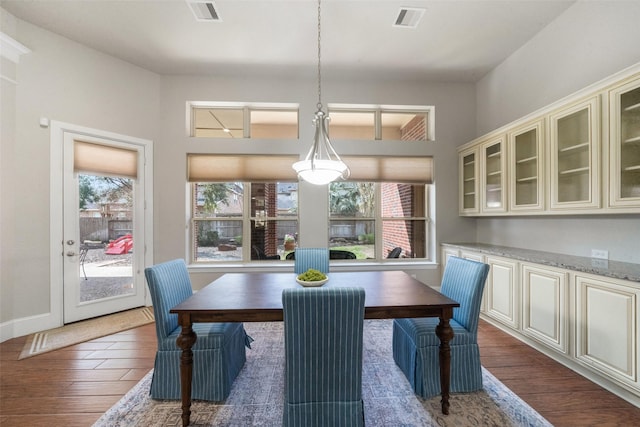 dining space with plenty of natural light and dark hardwood / wood-style flooring