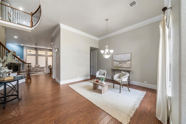 living area with a high ceiling, crown molding, a notable chandelier, and dark hardwood / wood-style flooring