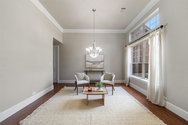 living area featuring dark hardwood / wood-style flooring, ornamental molding, a wealth of natural light, and an inviting chandelier