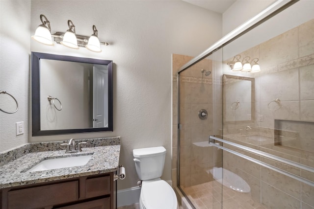 full bath featuring toilet, a shower stall, and vanity