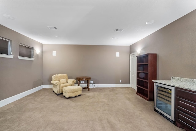 living area featuring light colored carpet and wine cooler