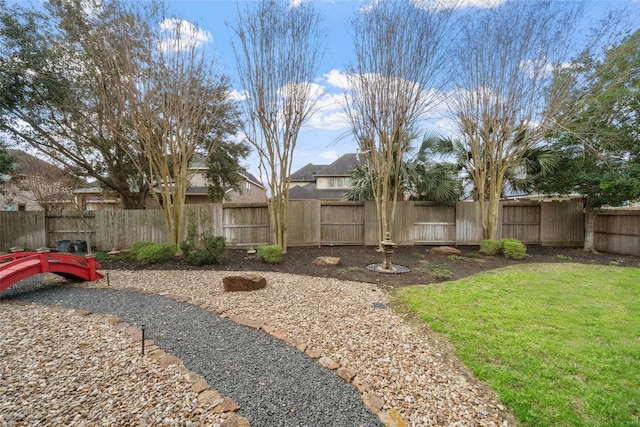 view of yard with a fenced backyard and a gate