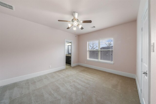 spare room featuring light carpet and ceiling fan