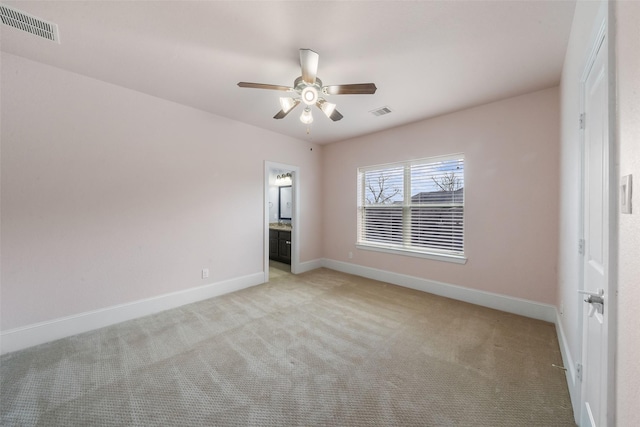 unfurnished room featuring baseboards, visible vents, and light colored carpet