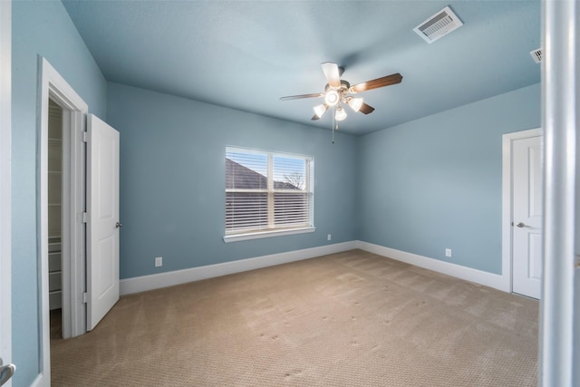 unfurnished bedroom with a ceiling fan, visible vents, light carpet, and baseboards