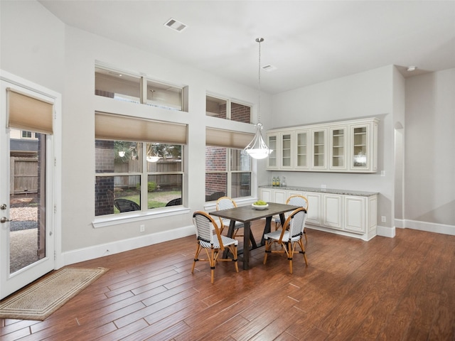 dining area featuring dark wood-style floors, baseboards, and visible vents