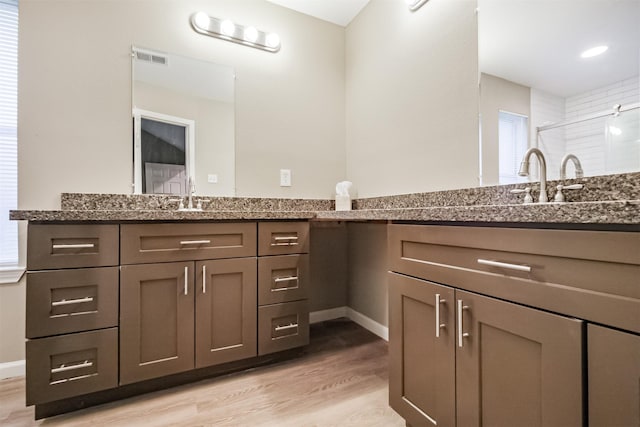 bathroom featuring vanity, hardwood / wood-style floors, and a shower with shower door