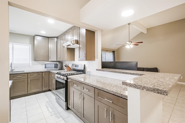 kitchen with stainless steel appliances, kitchen peninsula, sink, and backsplash