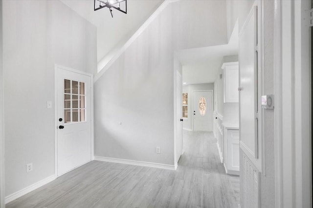 entryway with a towering ceiling and light wood-type flooring