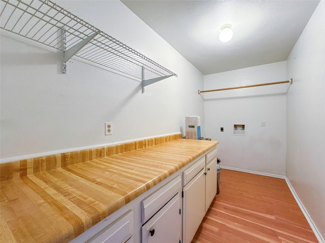 laundry room with washer hookup, cabinets, light hardwood / wood-style floors, and hookup for an electric dryer