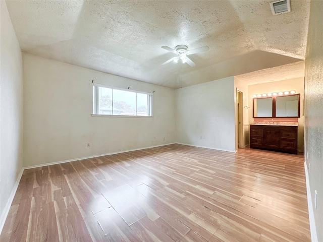 empty room featuring ceiling fan, a textured ceiling, and light wood-type flooring