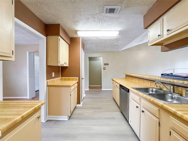 kitchen featuring dishwasher, sink, a textured ceiling, and light wood-type flooring