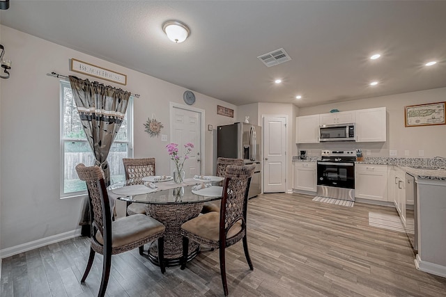 dining space with sink and light wood-type flooring