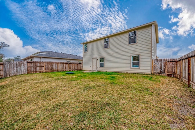 rear view of house featuring a yard