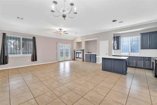 kitchen with pendant lighting, light tile patterned flooring, a healthy amount of sunlight, and a kitchen island