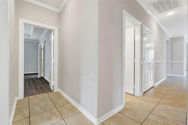 hallway with crown molding and light tile patterned floors