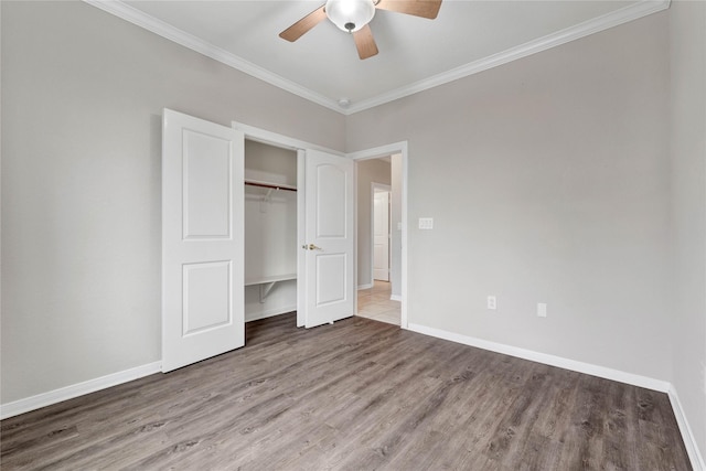 unfurnished bedroom featuring ceiling fan, ornamental molding, hardwood / wood-style floors, and a closet