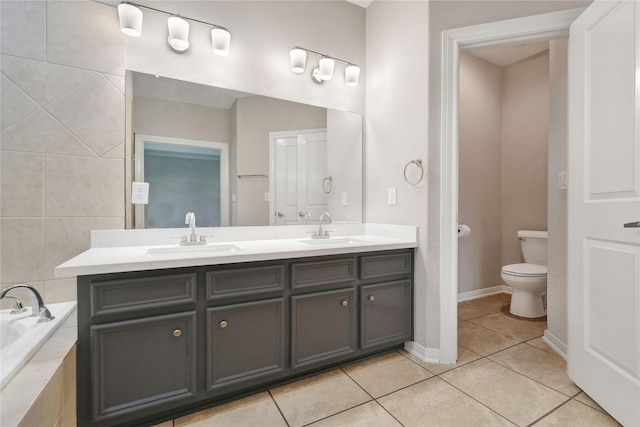 bathroom with tile patterned floors, toilet, vanity, and tiled tub