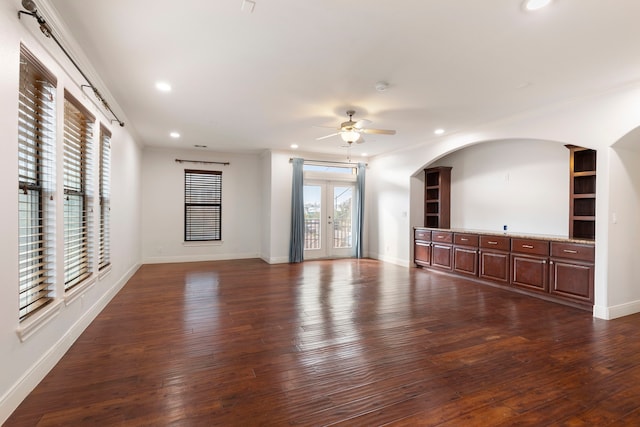 unfurnished living room featuring ornamental molding, dark hardwood / wood-style floors, ceiling fan, and french doors