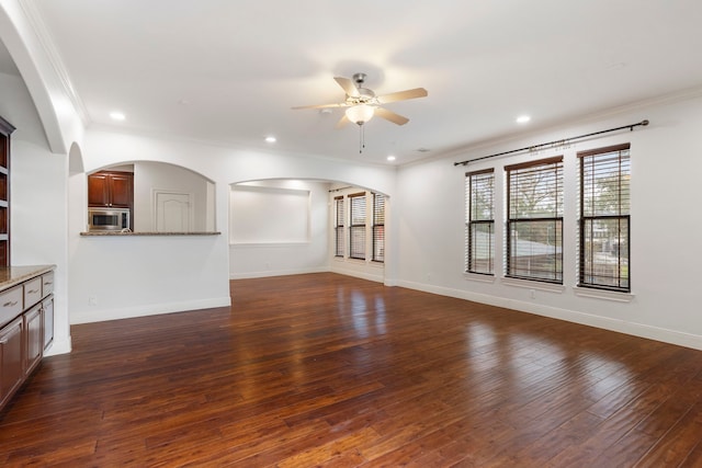 unfurnished living room featuring crown molding, dark wood-type flooring, and ceiling fan