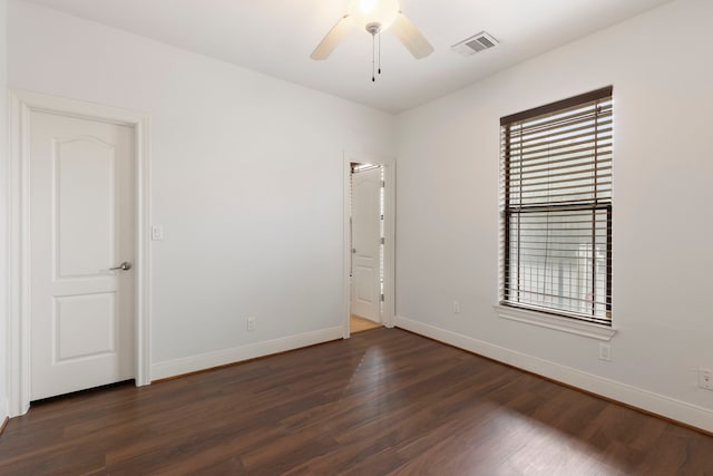 spare room with dark hardwood / wood-style floors and ceiling fan