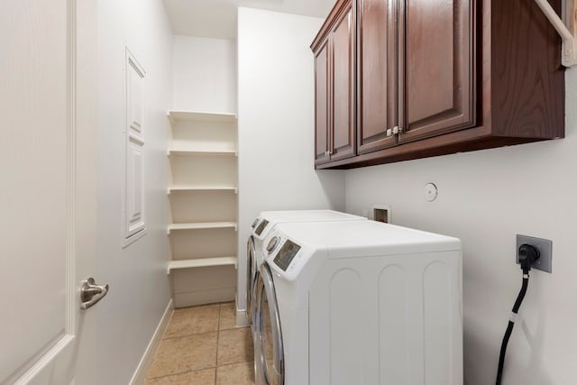 washroom featuring cabinets and washer and clothes dryer