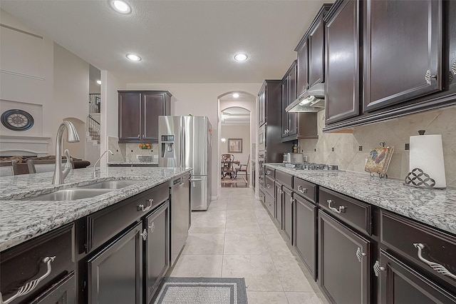 kitchen featuring light stone counters, appliances with stainless steel finishes, sink, and tasteful backsplash