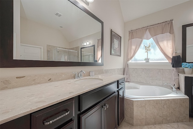 bathroom with vaulted ceiling, shower with separate bathtub, and vanity