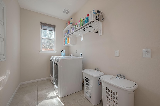 laundry room featuring washing machine and dryer and light tile patterned floors