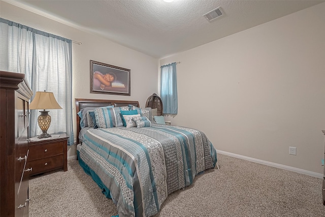 bedroom with light colored carpet and a textured ceiling