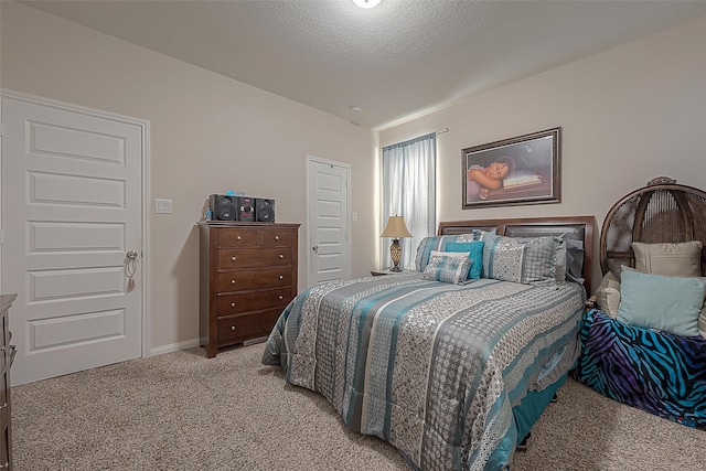 bedroom featuring light carpet and a textured ceiling