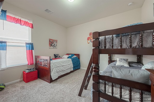 bedroom with multiple windows and light carpet