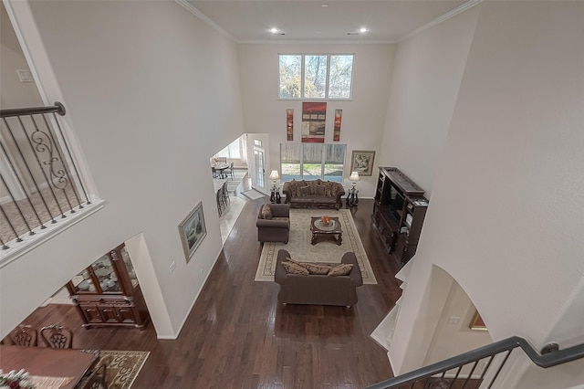 living room featuring dark hardwood / wood-style flooring, crown molding, and a wealth of natural light